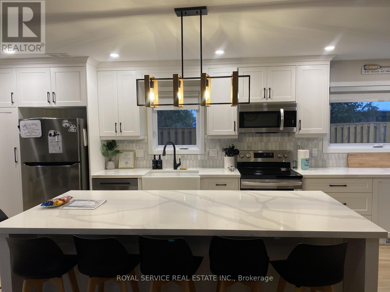 A kitchen with white cabinets and a marble countertop.