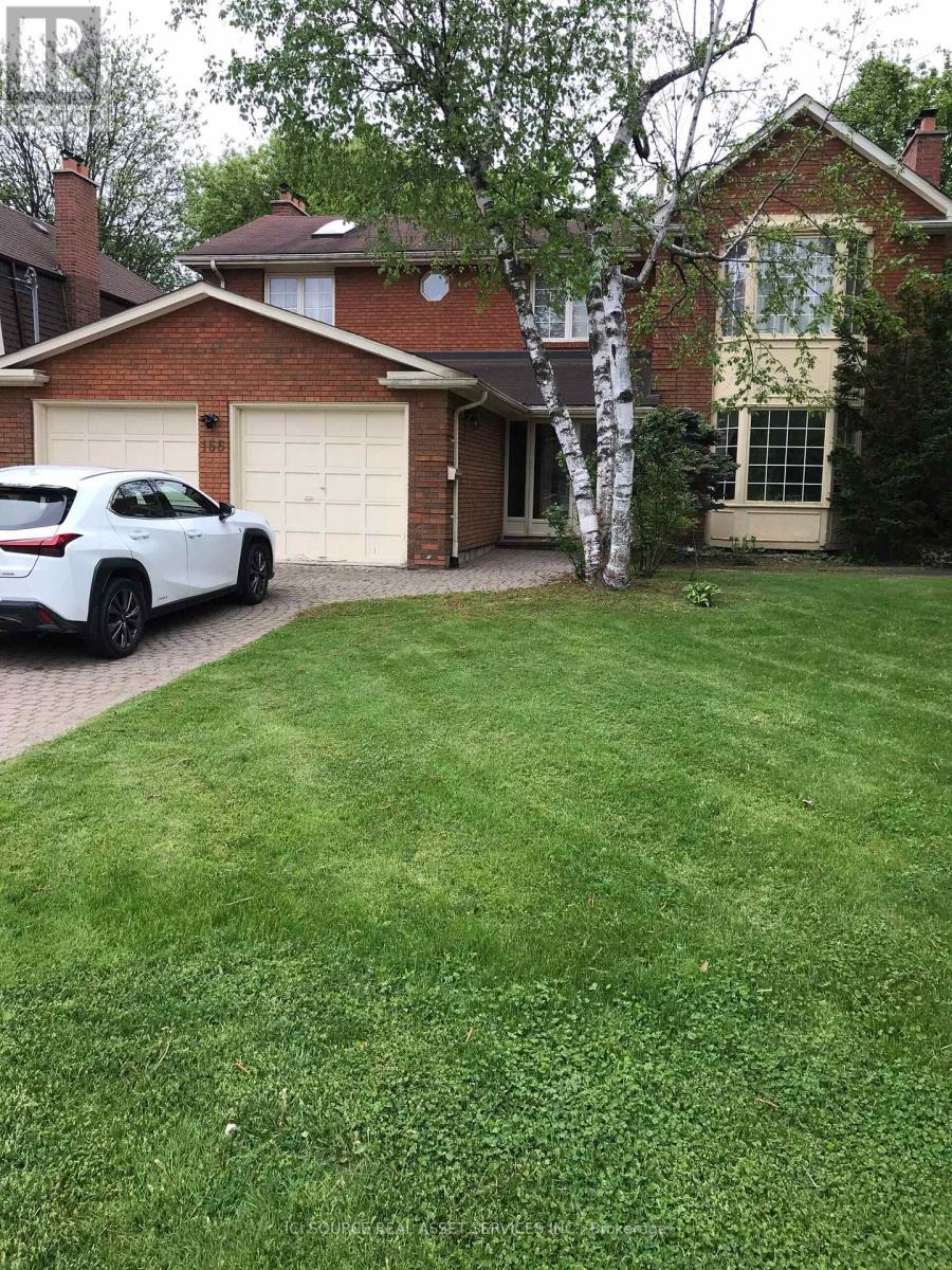 A white car is parked in front of a house.