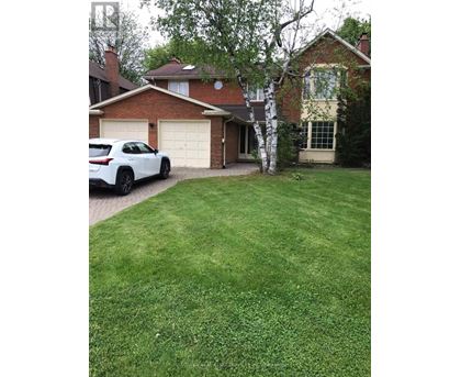 A white car is parked in front of a house.