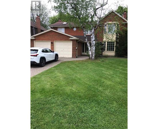 A white car is parked in front of a house.