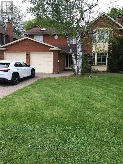 A white car is parked in front of a house.