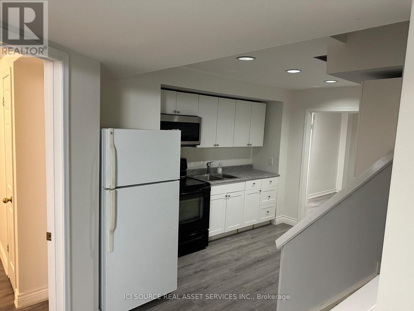 A kitchen with white appliances and cabinets.