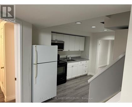 A kitchen with white appliances and cabinets.