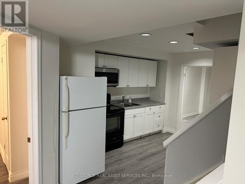 A kitchen with white appliances and cabinets.