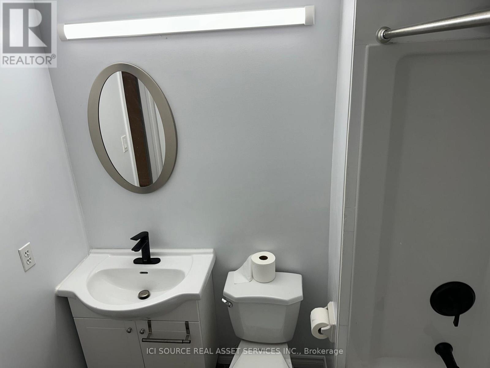 A bathroom with a sink, toilet and mirror.
