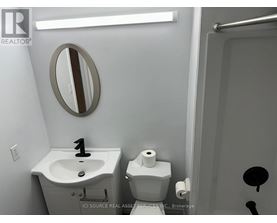A bathroom with a sink, toilet and mirror.
