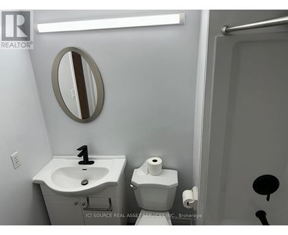 A bathroom with a sink, toilet and mirror.