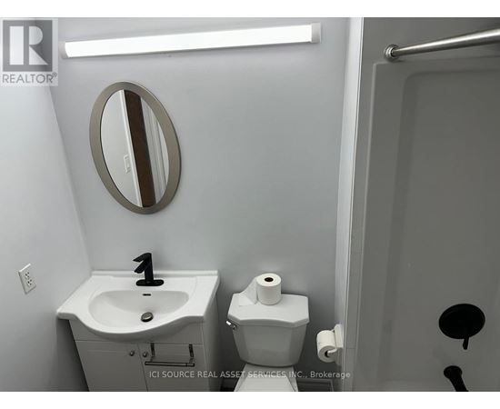 A bathroom with a sink, toilet and mirror.
