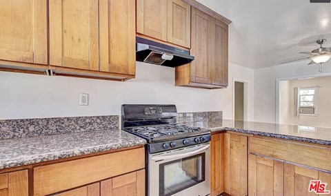 A kitchen with wooden cabinets and a granite countertop.