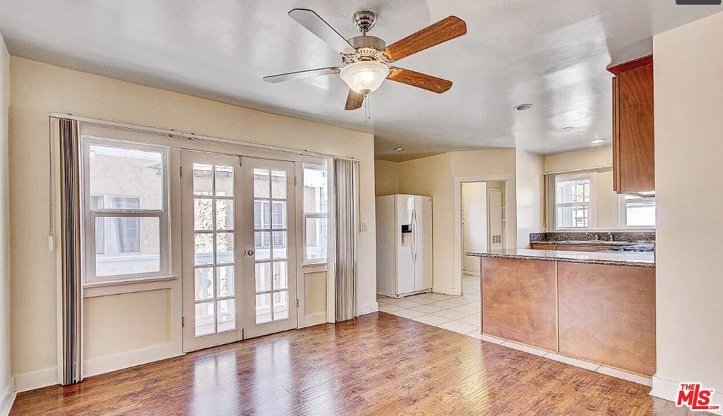 A spacious room with a ceiling fan and sliding glass doors.