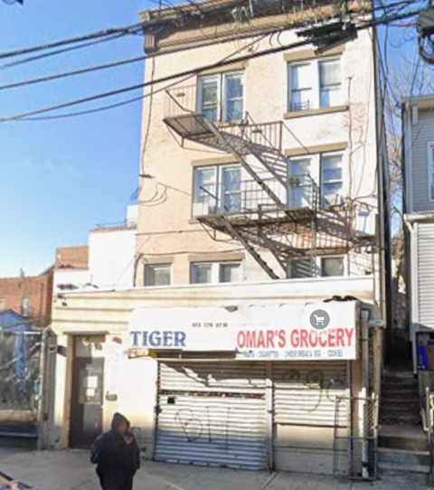 A person is walking past a storefront with the name Tiger on it.