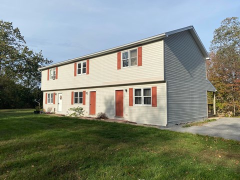 A two-story house with a grey exterior and red trim.