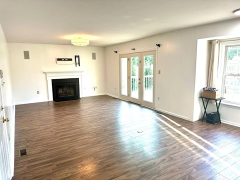 A living room with a fireplace and wood flooring.