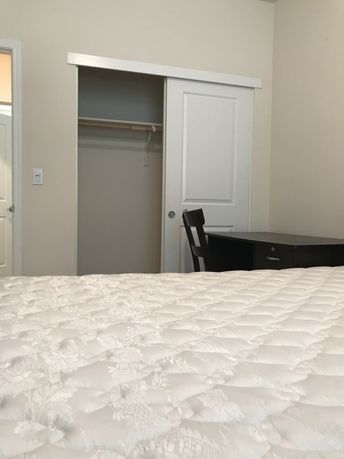 A white mattress with a floral pattern is on a bed in a bedroom.