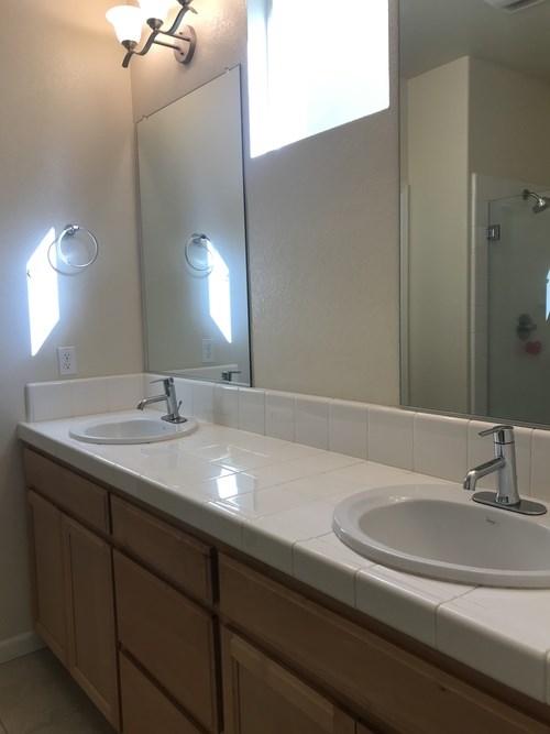 A bathroom with two sinks and a large mirror.