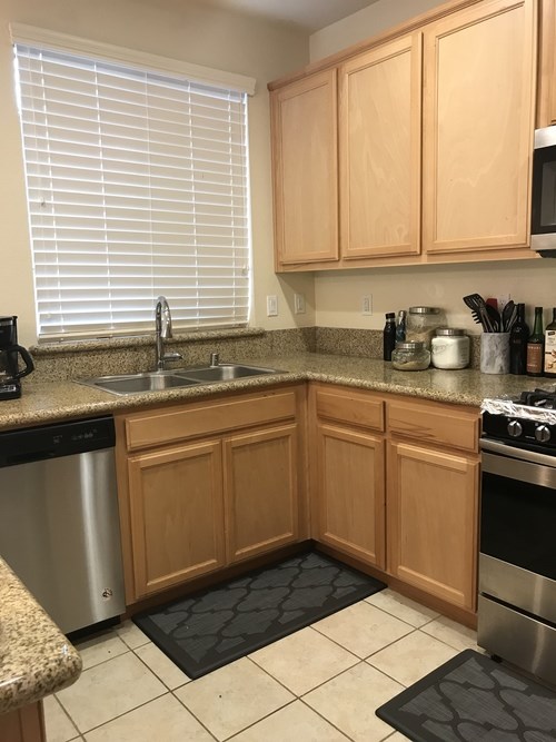 A kitchen with wooden cabinets and a granite countertop.