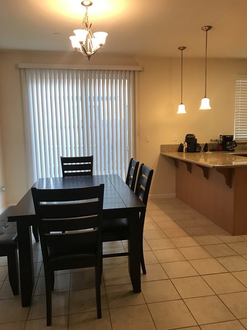 A dining room with a table and chairs.