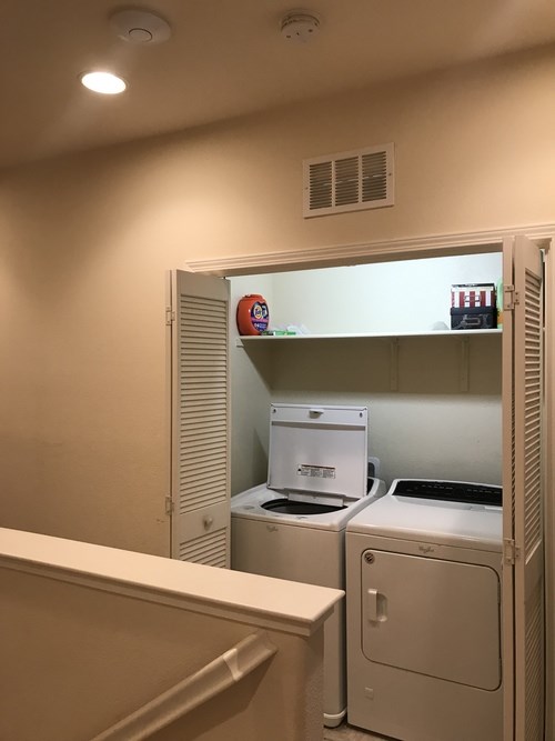 A small laundry room with a washer and dryer.