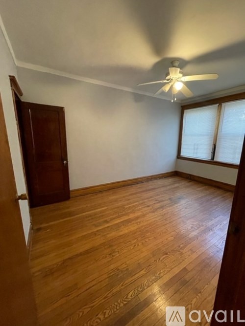 A room with wooden flooring and a ceiling fan.