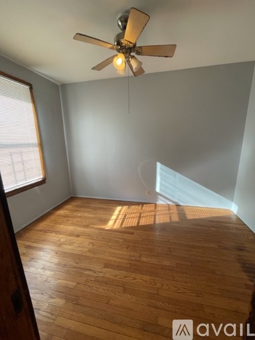 A room with wooden flooring and a ceiling fan.