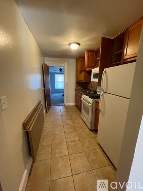 A kitchen with white appliances and brown cabinets.