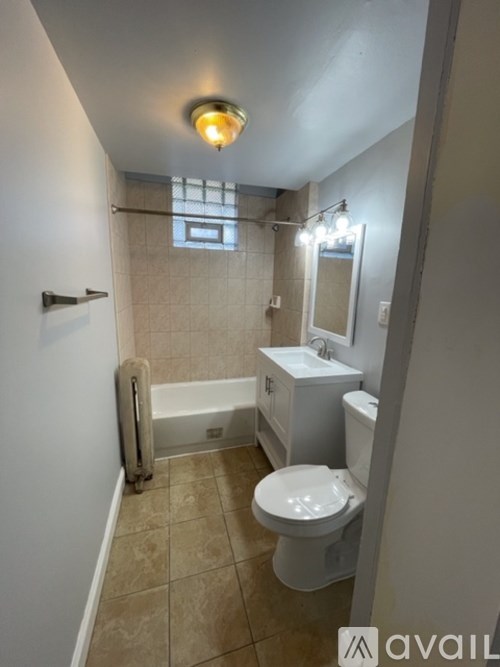 A bathroom with a toilet, sink, and bathtub.