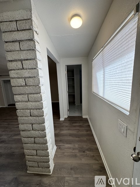 A room with a white column and wooden flooring.