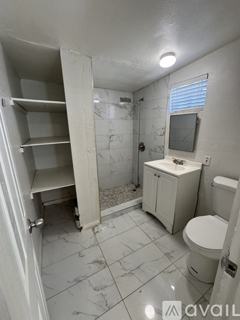 A bathroom with a toilet, sink, and shower.