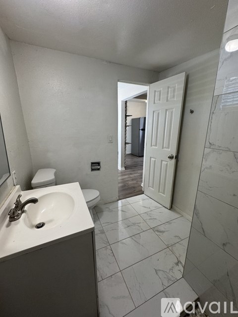 A bathroom with a sink, mirror, and toilet.