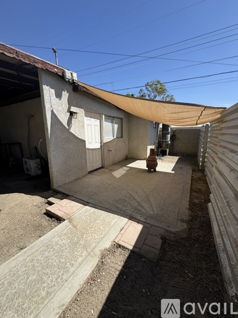 A backyard with a patio and a covered area.