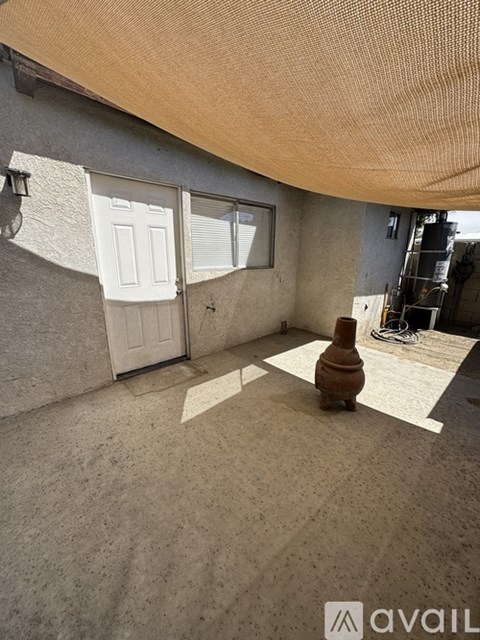 A room with a white door and a brown vase on the floor.