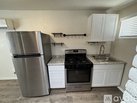 A kitchen with a stainless steel refrigerator, oven, and cabinets.