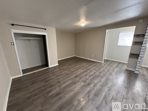 A room with wooden flooring and a white door.