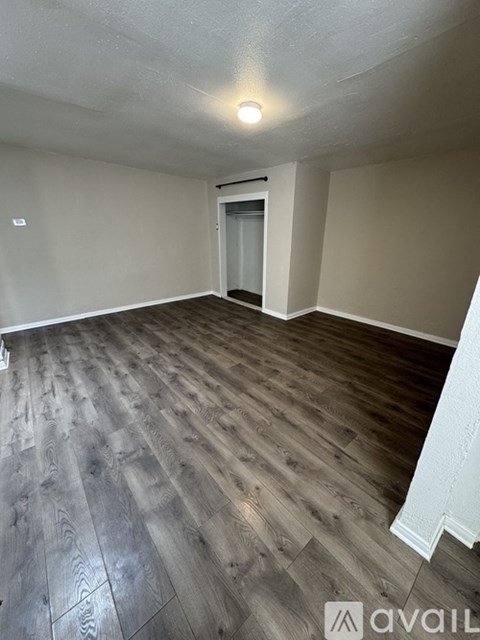 A room with wooden flooring and a white wall.