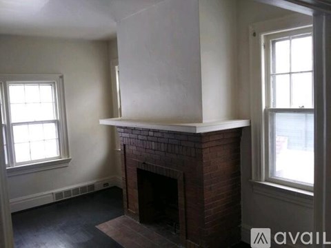 A room with a fireplace and two windows.