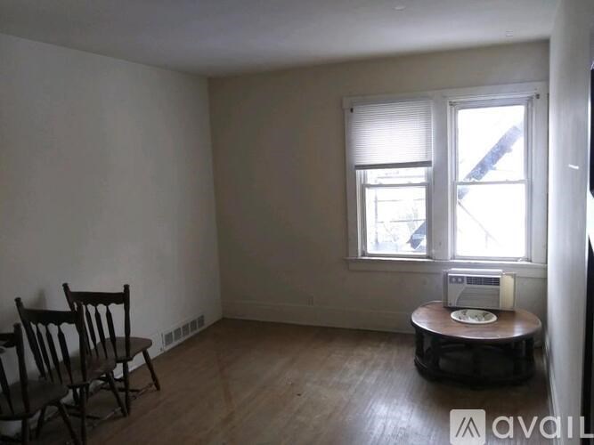 A room with a chair and a table with a phone on it.
