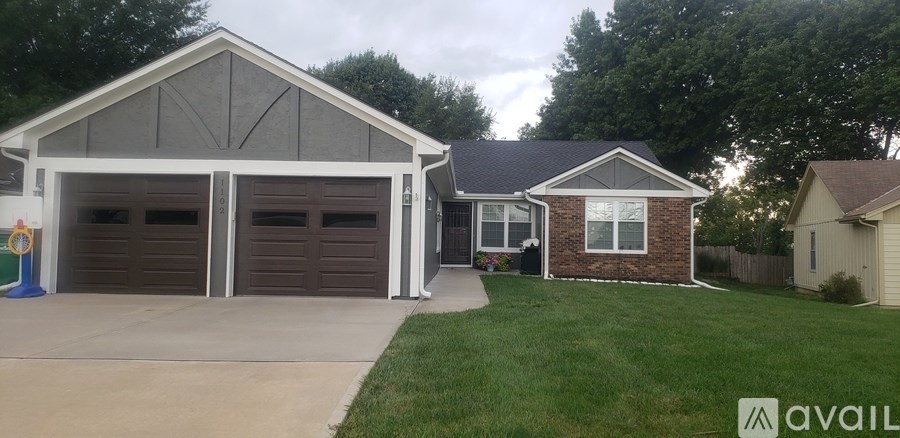 A two-car garage is attached to a brick house.