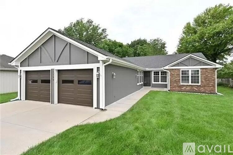 A house with a grey roof and a brick chimney is available for sale.
