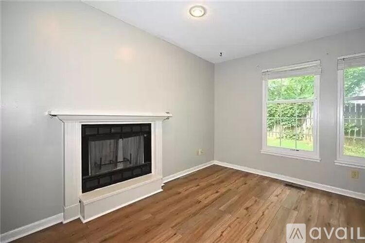 A room with a fireplace and two windows.