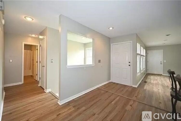 A spacious room with wooden floors and white walls.