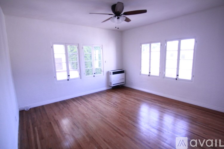 A room with wooden floors and a ceiling fan.