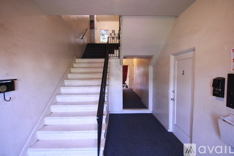 A staircase with a black railing and white steps leads to a door.
