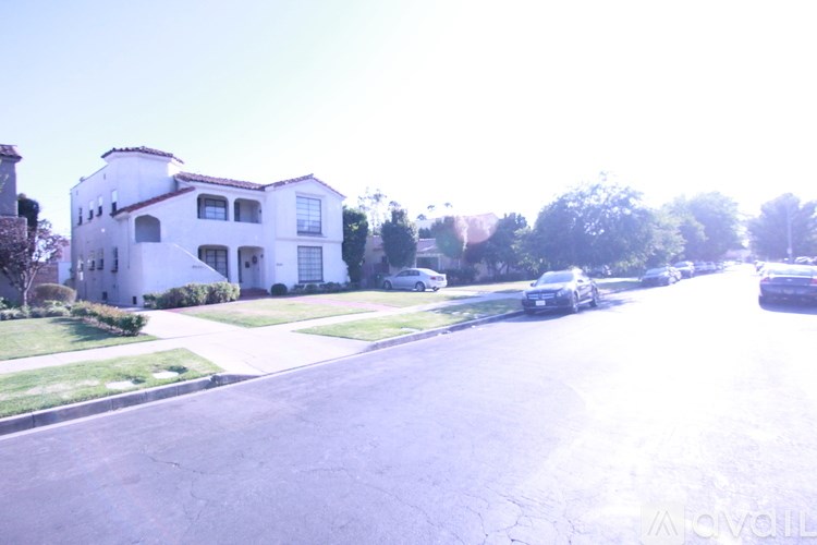 A white house with a black car parked in front.