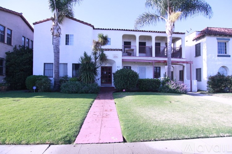 A white building with a red walkway in front.