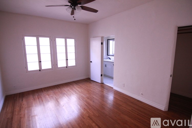 A room with a ceiling fan and wooden flooring.