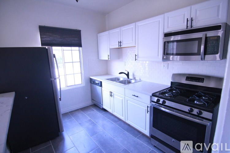 A kitchen with black appliances and white cabinets.