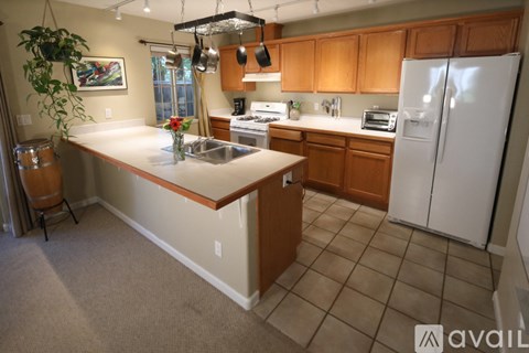 A kitchen with wooden cabinets and a white fridge.