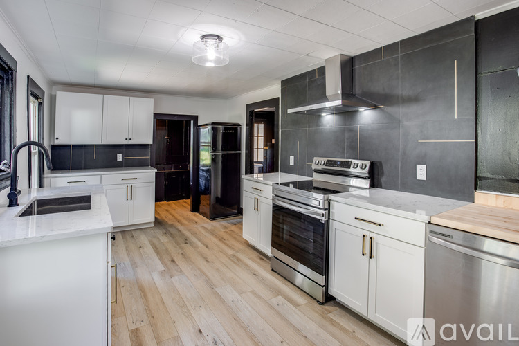 A modern kitchen with white cabinets and stainless steel appliances.