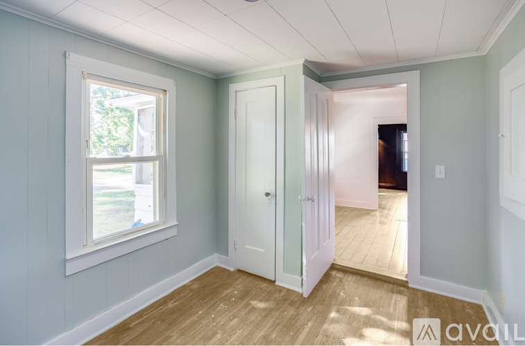A room with a window and a door leading to another room.
