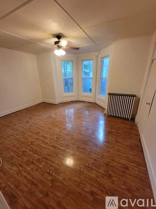 A room with wooden flooring and a ceiling fan.